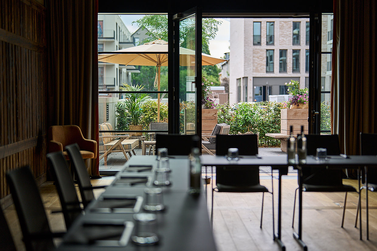 Foto aus dem Inneren eines Restaurants mit Blick auf die Außenterrasse