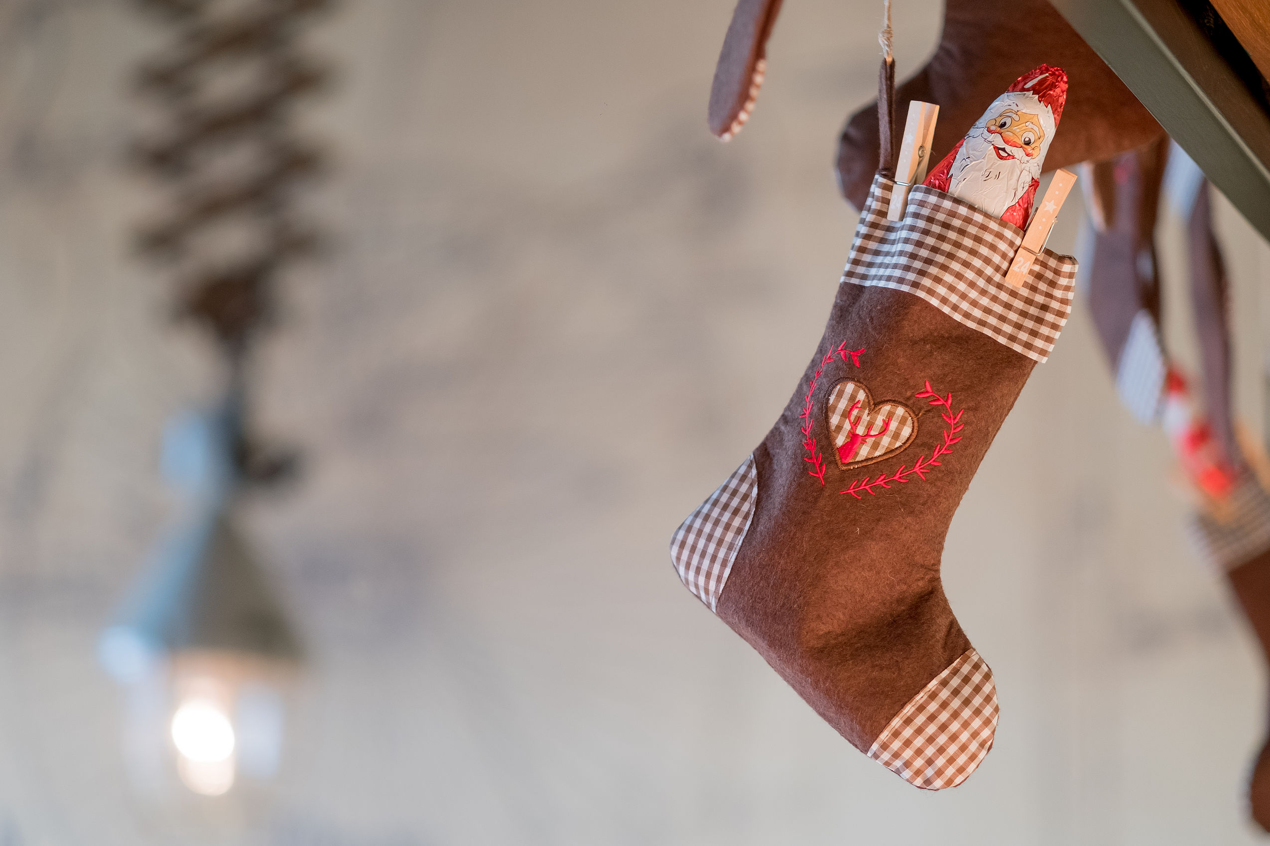 Eine Weihnachtssocke mit Herz darauf und einem kleinen Nikolaus darin