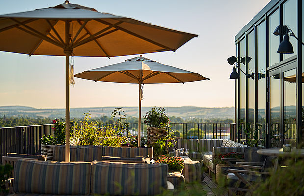 Bunte gemütliche Sitzecken unter einem Sonnenschirm in der Skybar in Göttingen