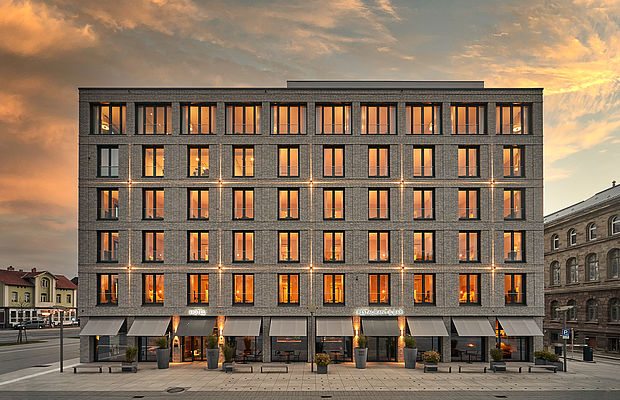 Die Vorderansicht des Hotel FREIgeist Innenstadt in der Abenddämmerung