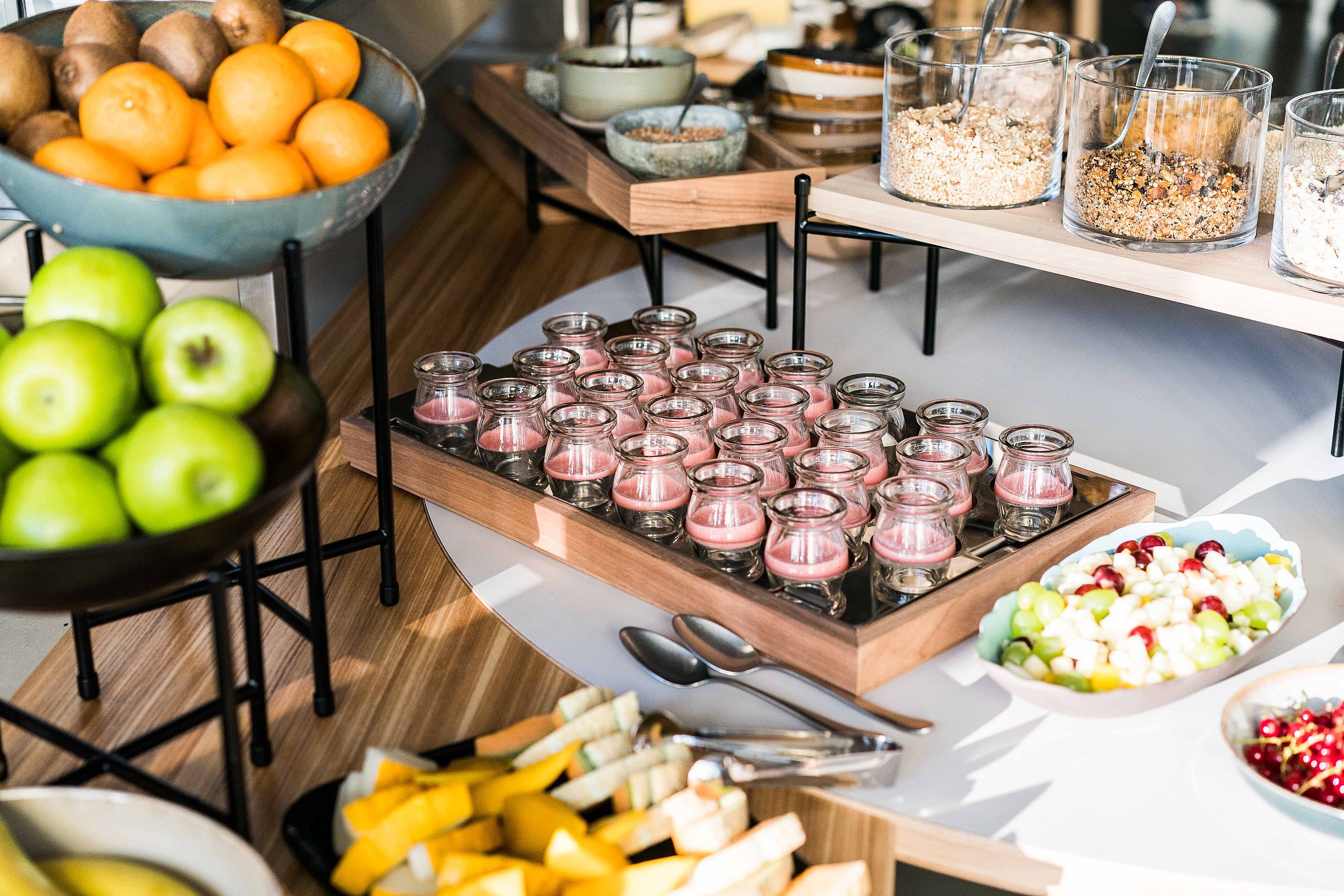 Nahaufnahme des Frühstücksbuffet mit verschiedenen Säften, Müslis und Obst im Hotel FREIgeist in Göttingen