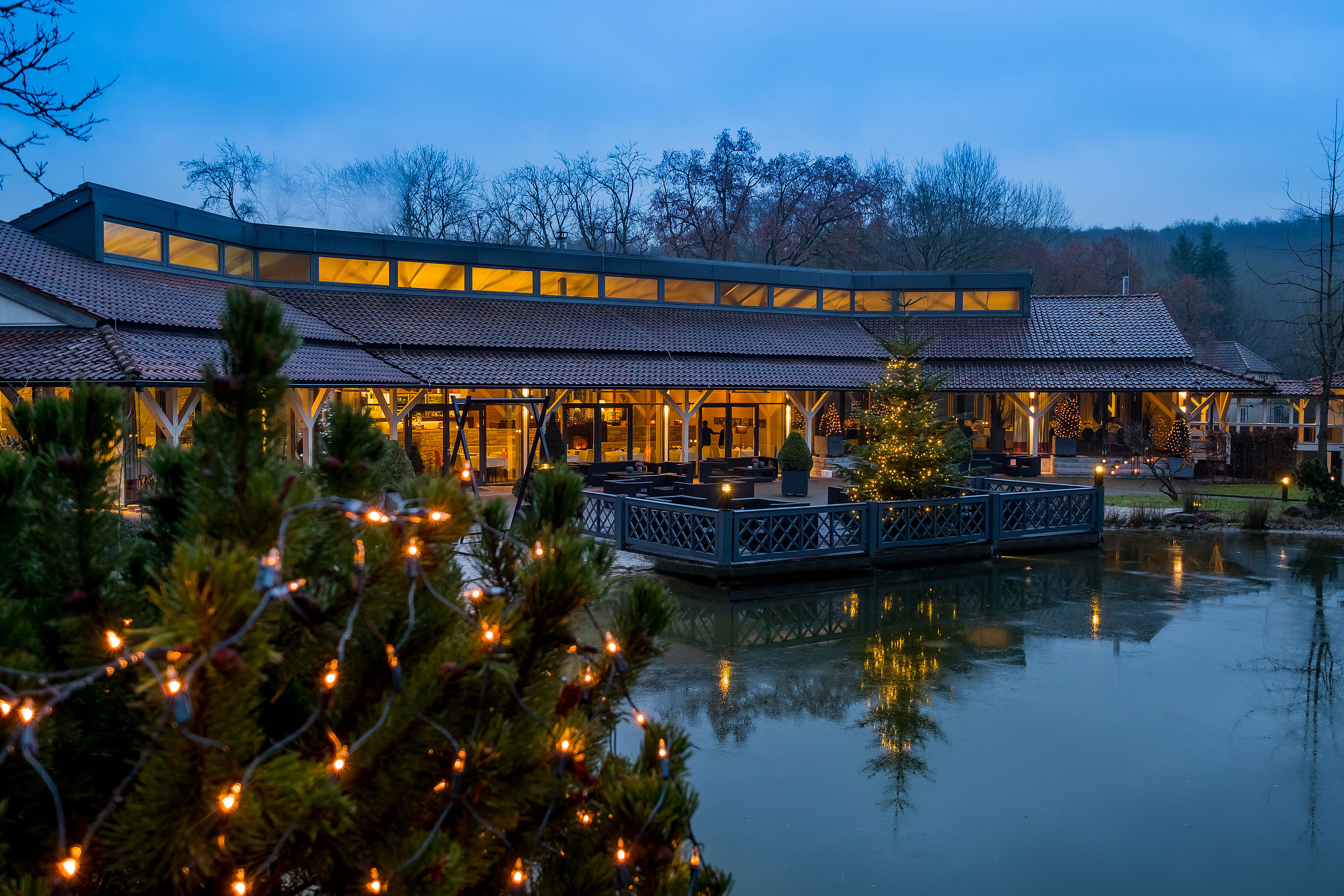 Das beleuchtete Terrasse über dem Teich des Hotel FREIgeist mit schöner Weihnachtsdekoration