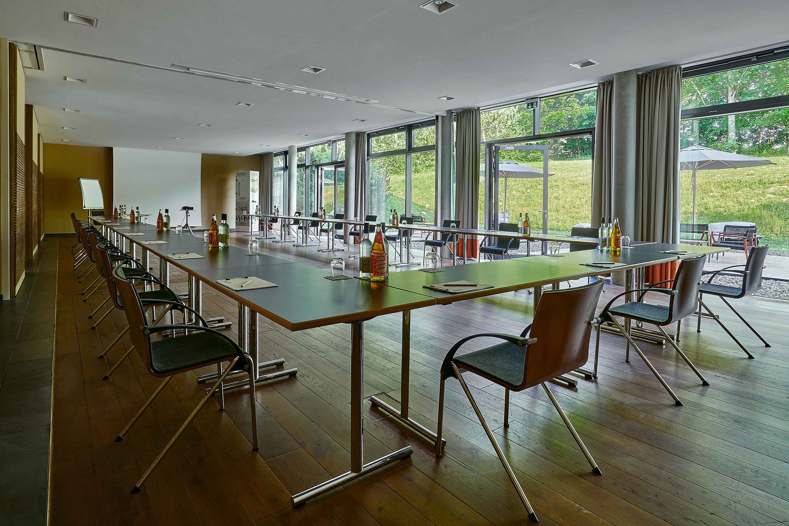 Übersicht über der Tagungsräume "FREIraum I, II & III" im Hotel FREIgeist Northeim mit u-förmigen Tischen in der Mitte