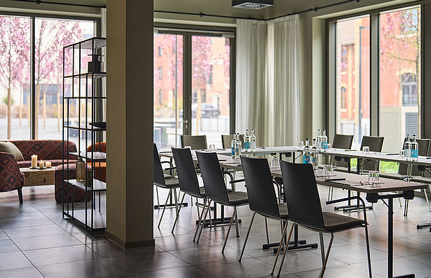Konferenztisch und Stühle und eine gemütliche Sitzecke neben einem Fenster