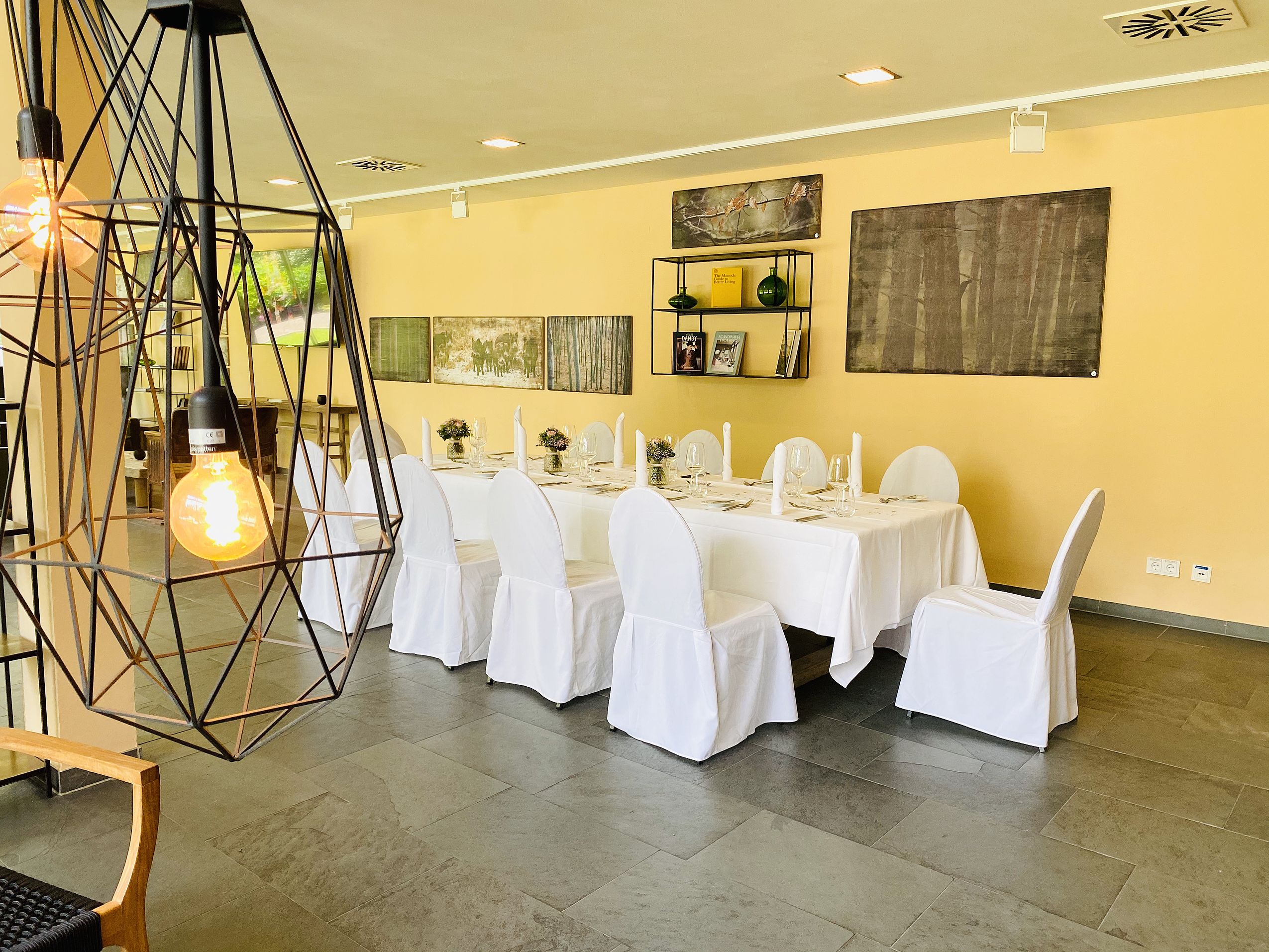 Stilvoller privater Raum mit runder Festtafel und Wandkunst.