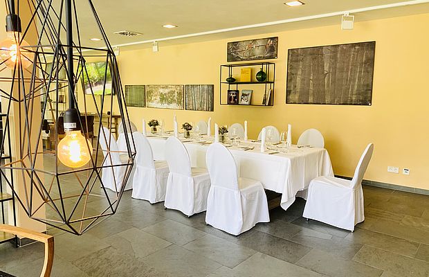 Stilvoller privater Raum mit runder Festtafel und Wandkunst.