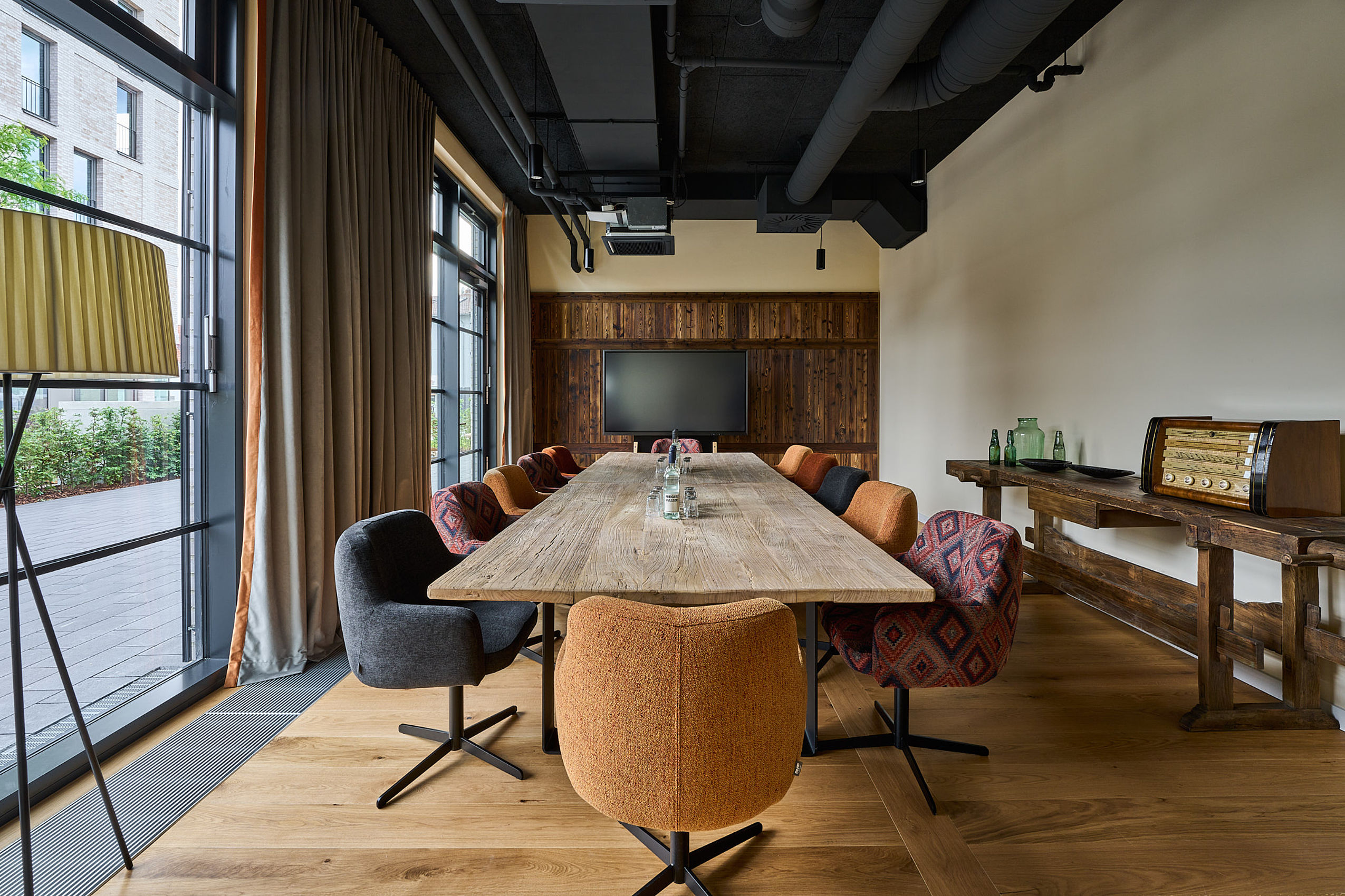 Ein langer Holztisch mit gemütlichen Stühlen in einem Meetingraum