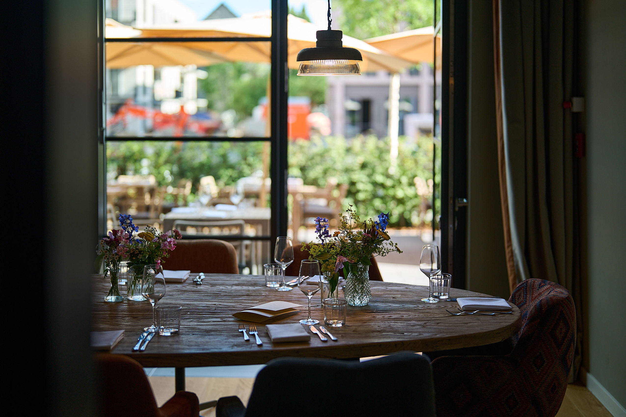 Ein schlicht dekorierter Tisch mit schönen Sommerblumen im Tagungsraum des Hotel FREIgeist Göttingen Nordstadt