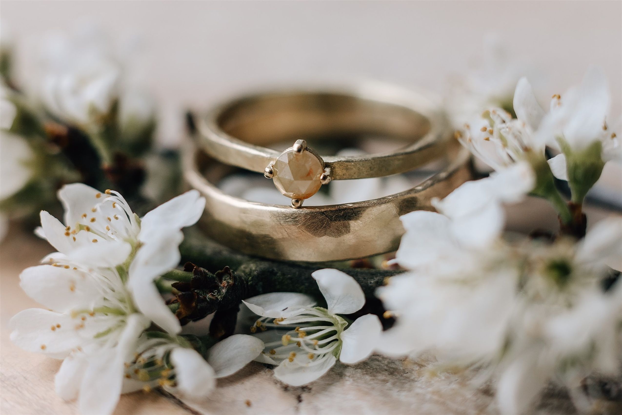 Nahaufnahme von einem Ehering umgeben von Blumen bei einer Hochzeit in Niedersachsen