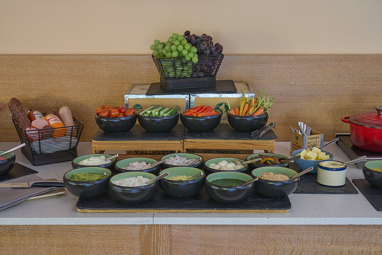 Blick auf verschiedene Soßen, Salate, Gemüse, Obst, Salami und andere Frühstücksleckereien im Restaurant in Northeim