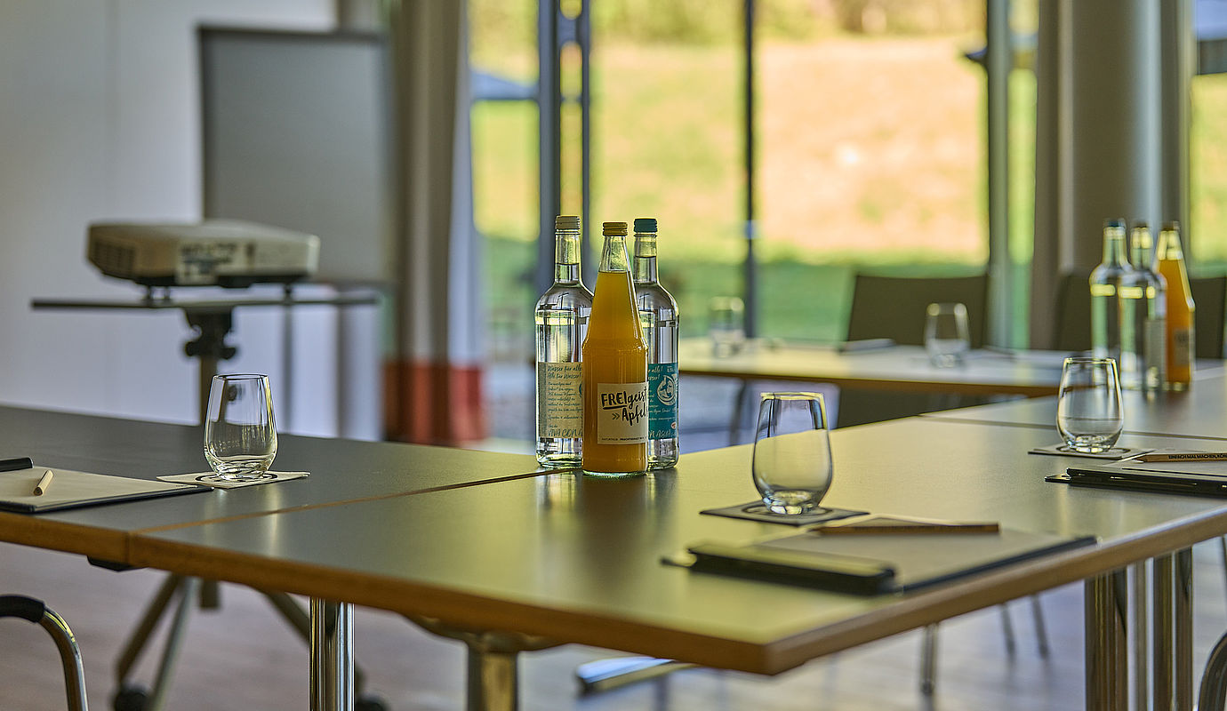 Ein aufgestellter Konferenztisch mit Gläsern und Flaschen mit Getränken