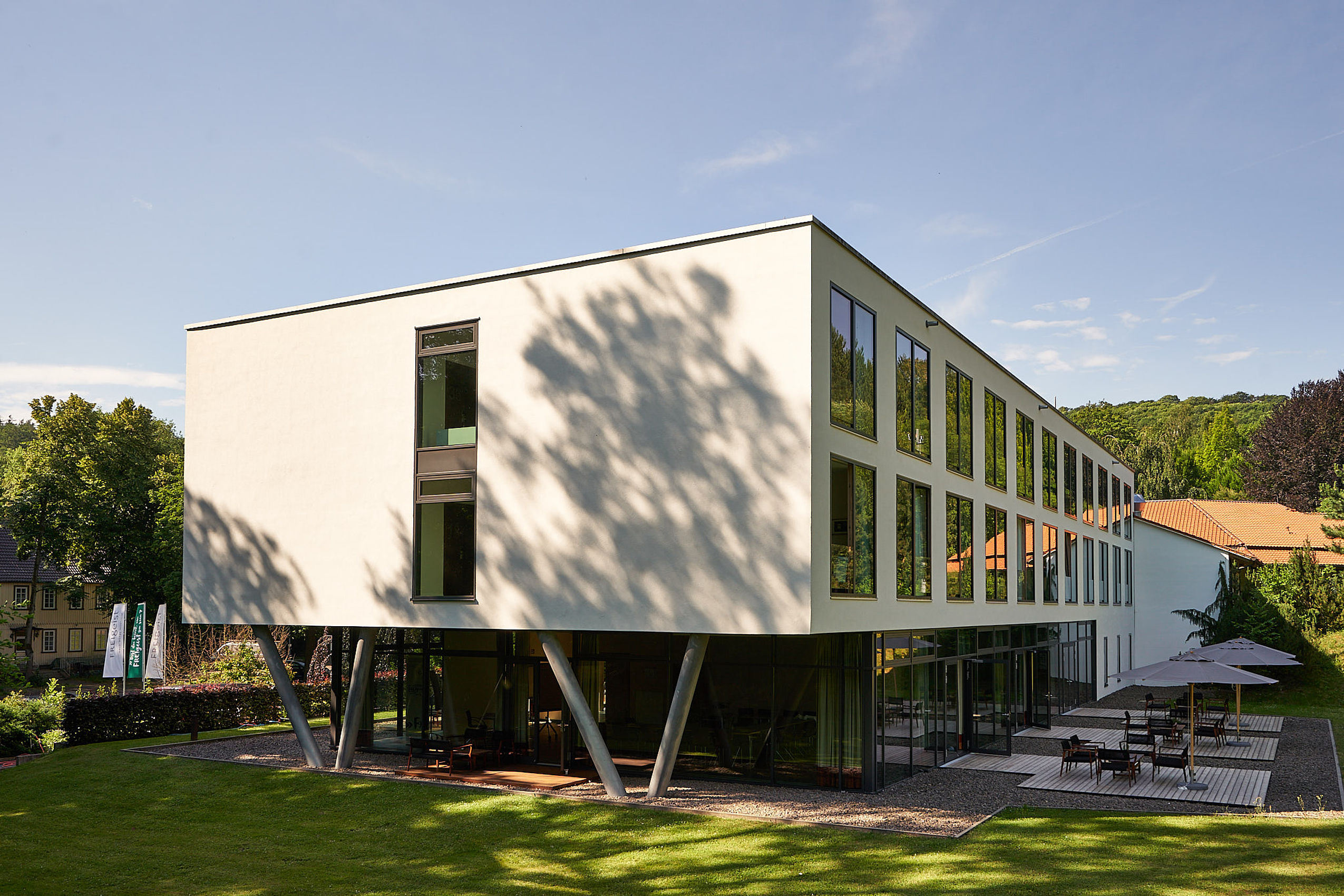 Vorderseite des FREIgeist Hotels Northeim und seiner Terrasse bei schönem Wetter