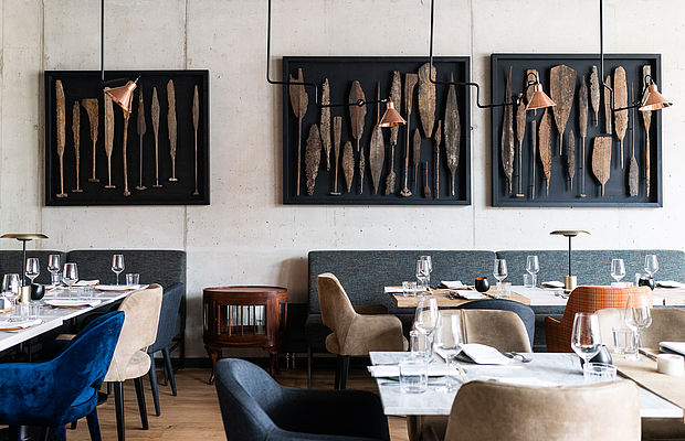 Blaue und beige Stühle, Tische und Designfotos an der Wand im Sushi-Restaurant Intuu