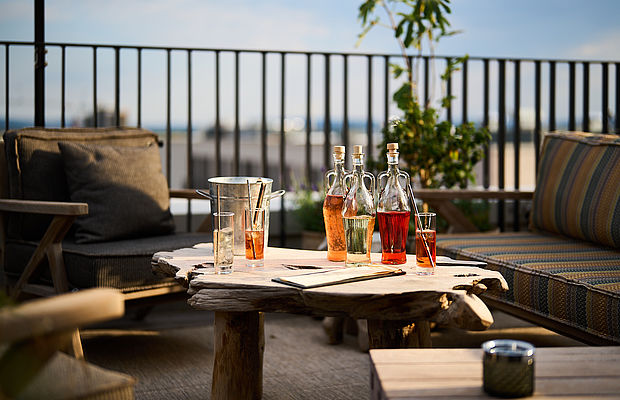 Getränke auf einem Tisch und eine Sitzecke in der Ecke einer Dachterrasse