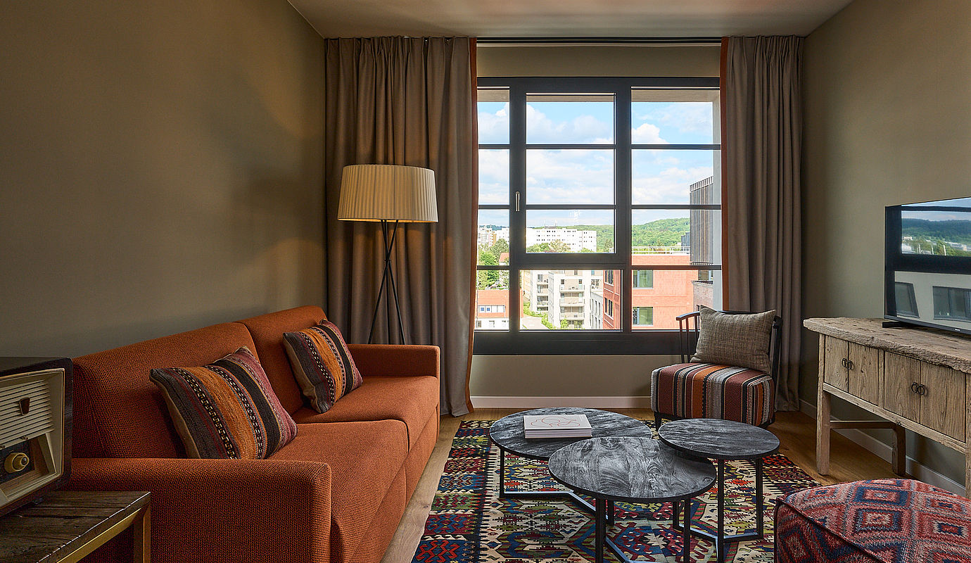 Ein gemütliches Hotelzimmer mit gemustertem Teppich und Kissen