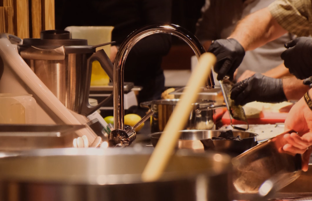 Viele Hände sind in der Küche am werkeln, schneiden und kochen. 