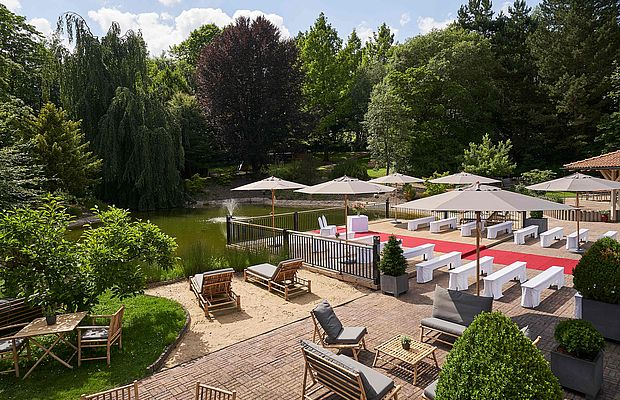 Die für eine Hochzeit dekorierte Terrasse mit Blick auf den schönen Teich des Hotel FREIgeist