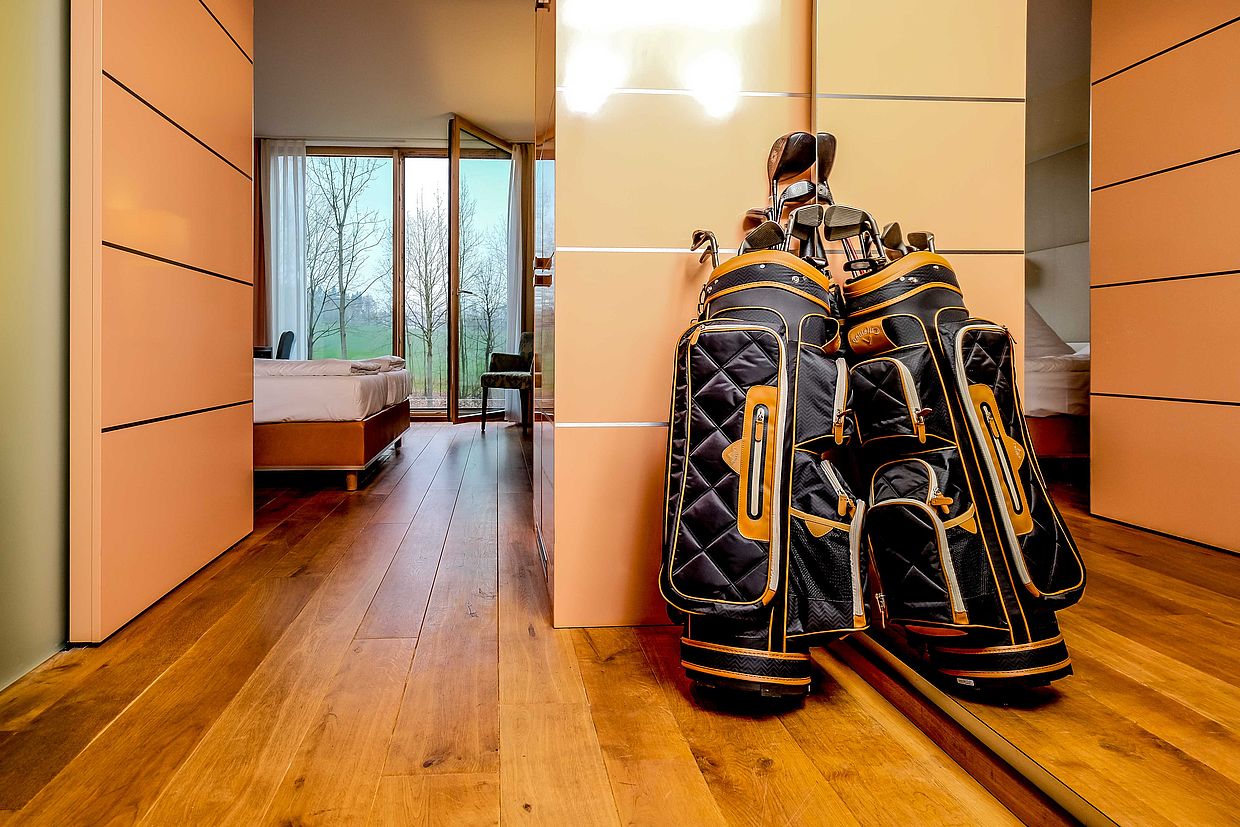 Zwei gepackte Golftaschen stehen vor einem Hotelzimmer im Golfhotel FREIgeist Northeim in Niedersachsen
