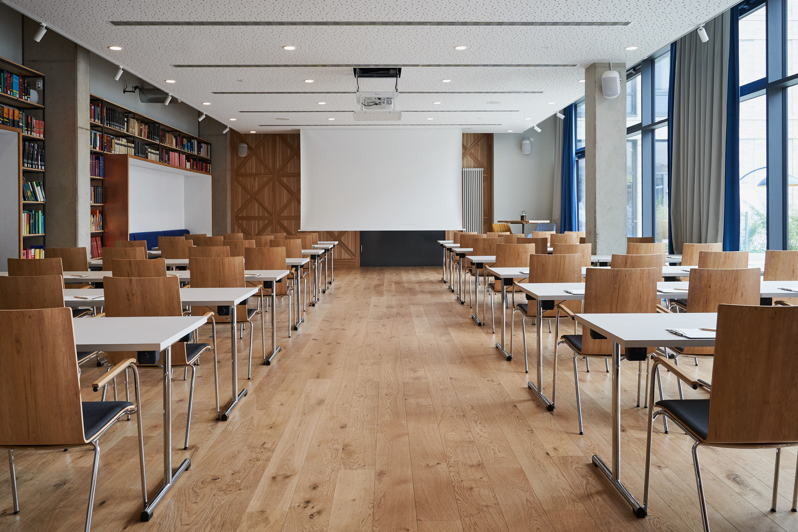 Zwei Reihen von Konferenztischen und Stühlen, die für eine Besprechung angeordnet sind