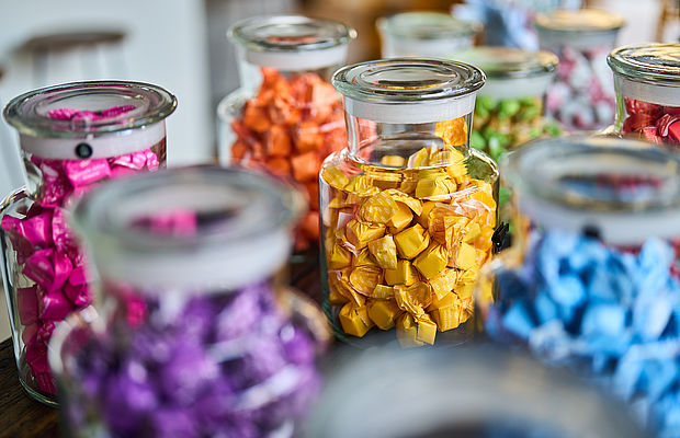 Mehrere Einmachgläser voller Bonbons nach Farben geordnet im Viani Alimentari im FREIgeist Hotel in Göttingen