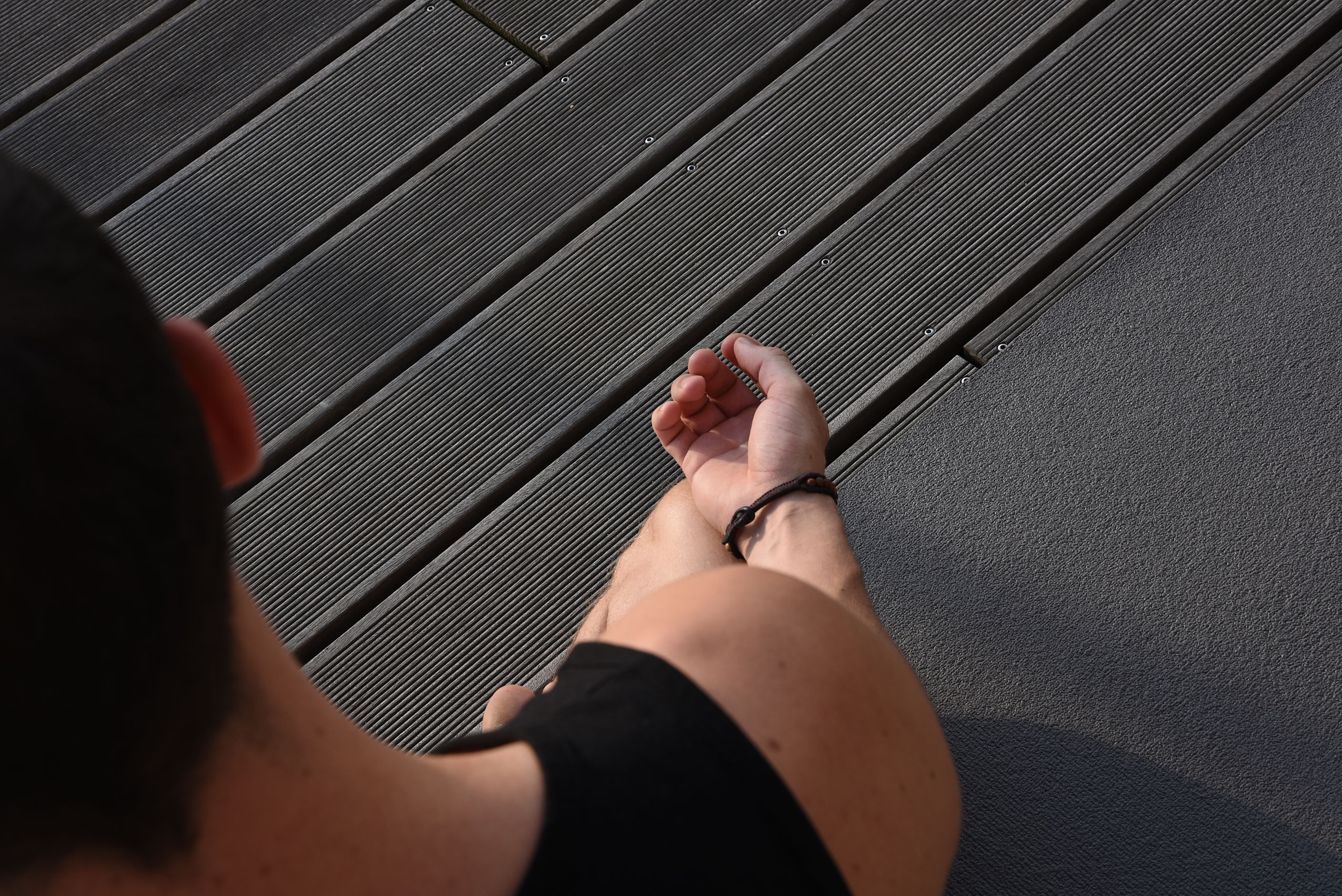 Aufnahme einer meditierenden Person von oben auf einem Holzboden
