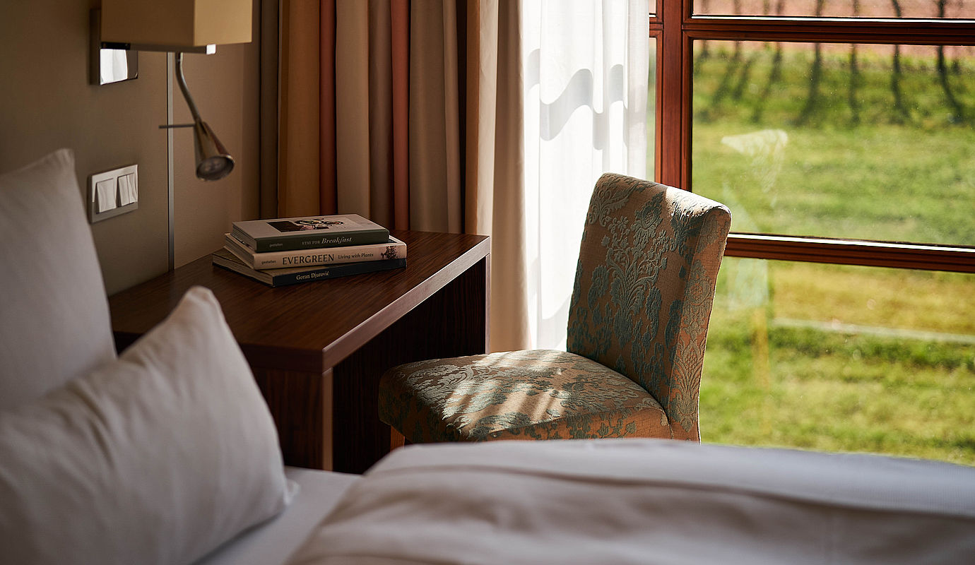 Nahaufnahme eines frisch bezogenen Betts mit grauer Bettwäsche in einem der FREIgeist Hotels
