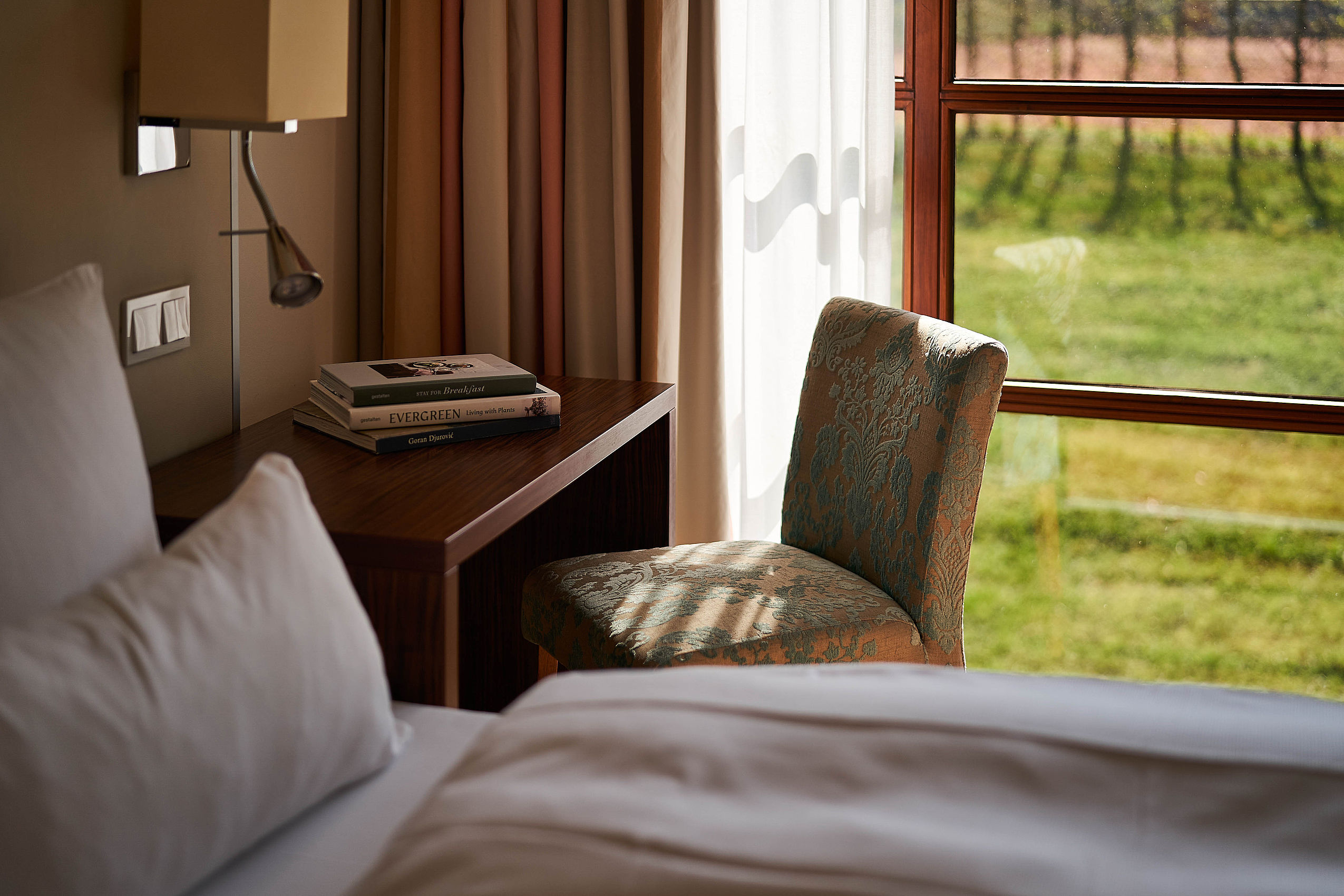 Nahaufnahme eines frisch bezogenen Betts mit grauer Bettwäsche in einem der FREIgeist Hotels
