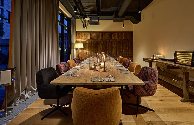 Private Dining mit Holztisch, Kerzen und gemütlicher Atmosphäre.