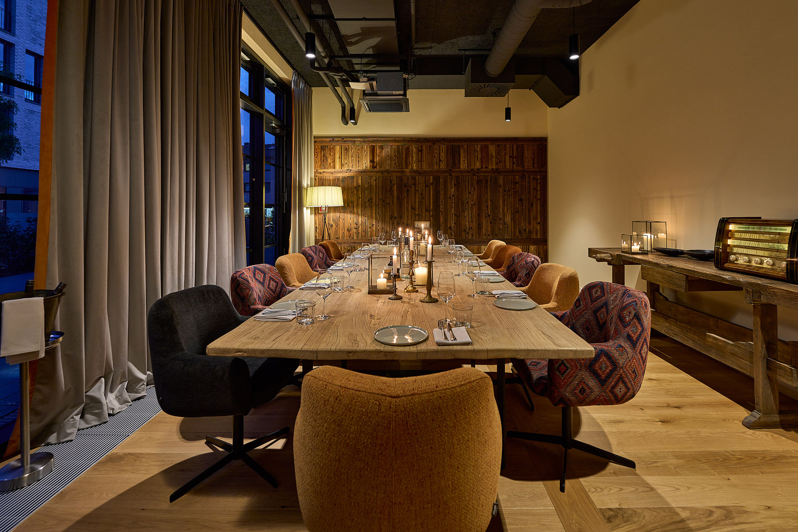 Private Dining mit Holztisch, Kerzen und gemütlicher Atmosphäre.