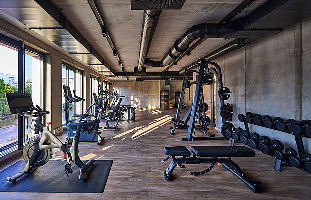 Blick auf das weitläufige, lichtdurchflutete Fitnessstudio mit mehreren Geräten