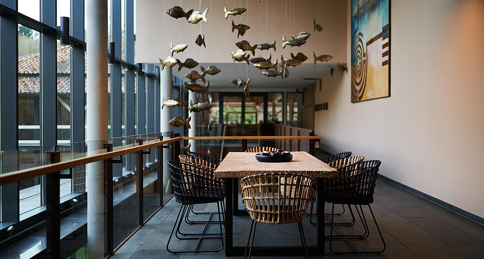 Die Lobby des Hotel FREIgeist Northeim mit goldenen Stühlen und lustiger Fischdekoration