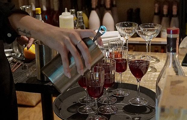 Ein Barkeeper richtet Cocktails in Gläsern an. 