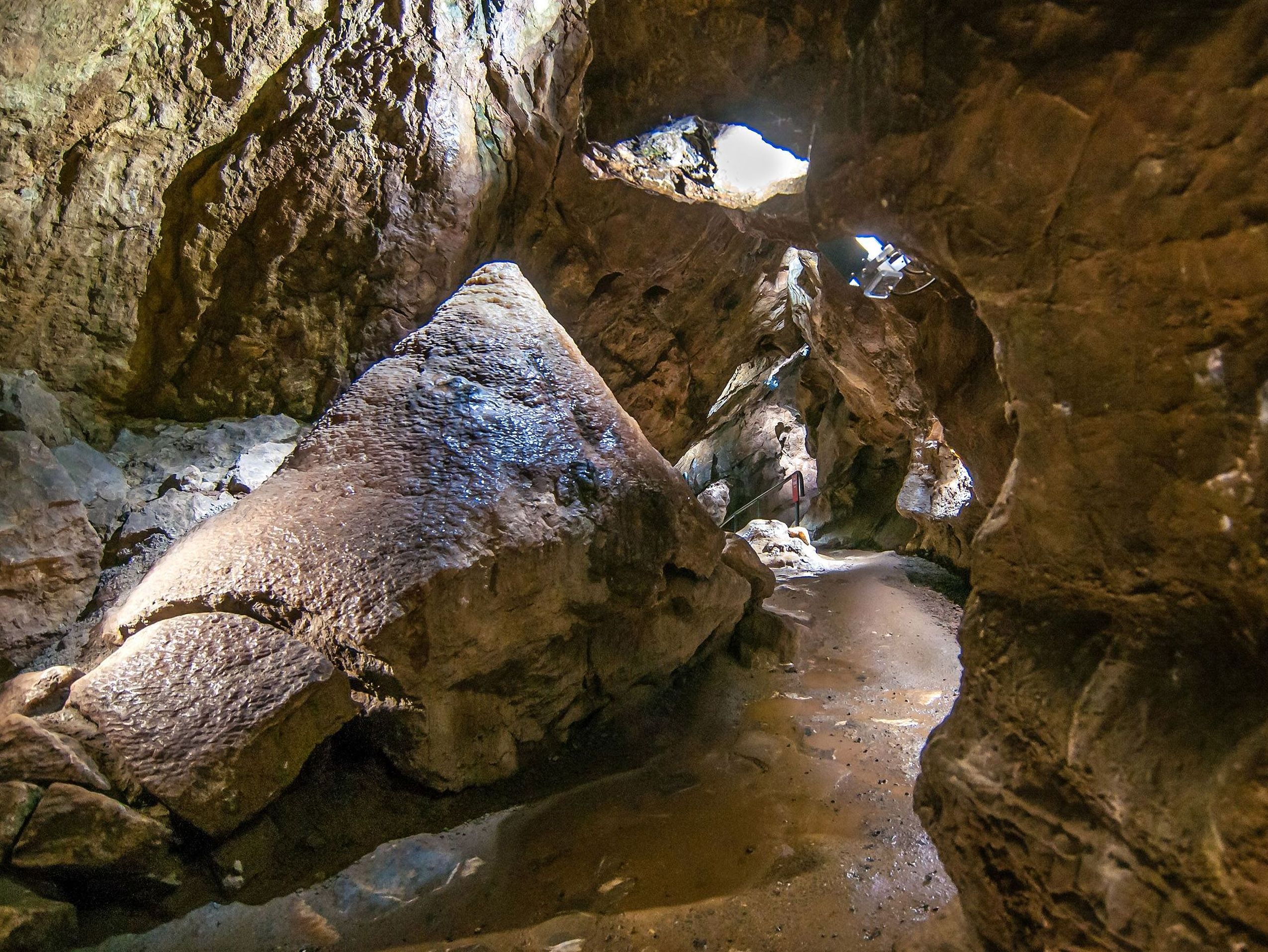 Aufnahme einer Tropfsteinhöhle von innen mit ein paar Sonnenstrahlen, die sie erhellen