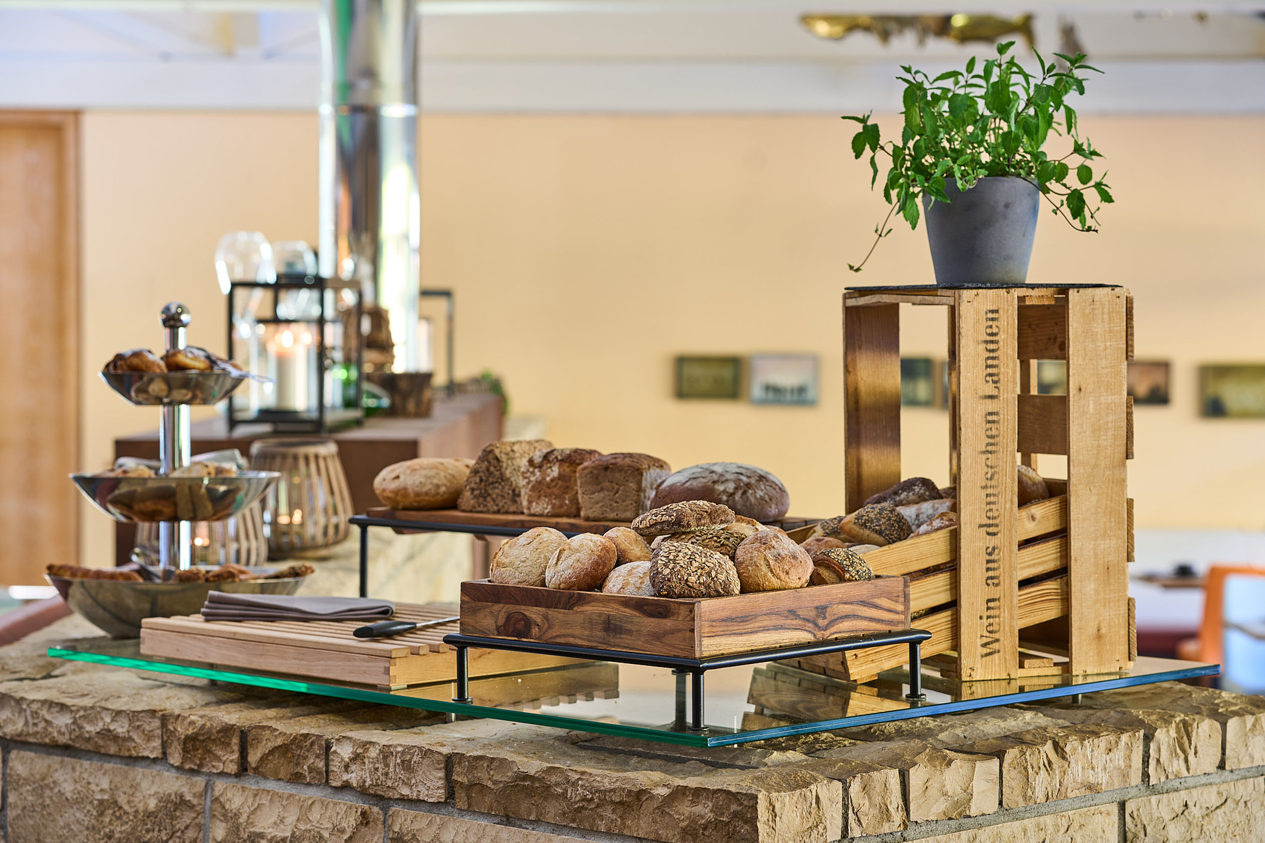Arrangierte Brotlaibe und Semmeln auf Holzbrettern beim Frühstück in Northeim