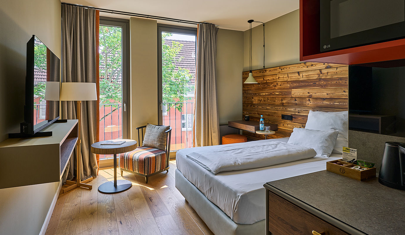 Blick auf ein Apartment in Göttingen mit Bett, Fernseher und Sitzecke