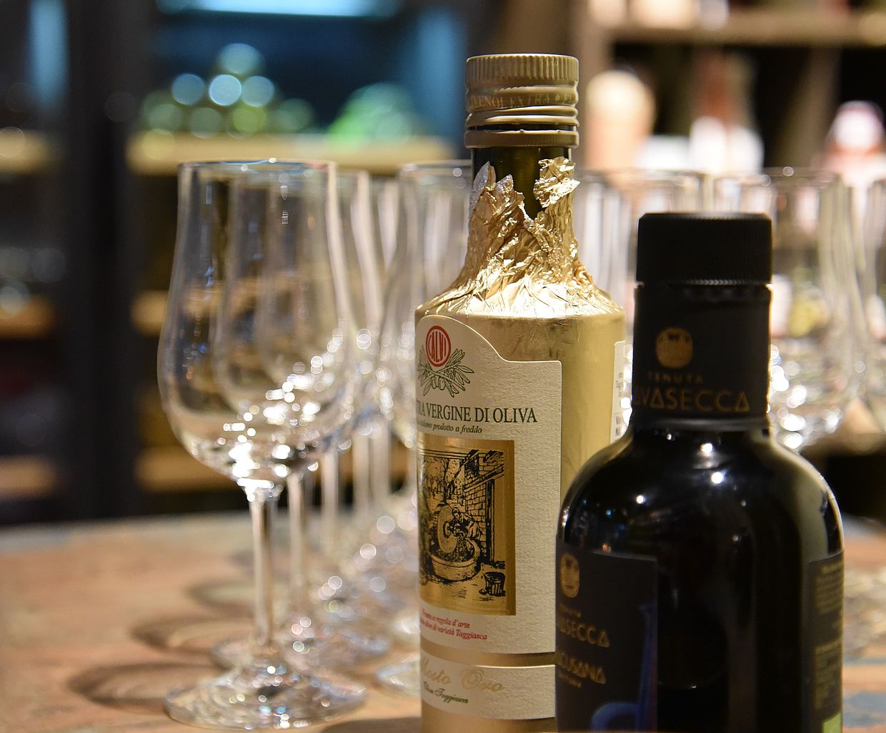 Olivenöl- und Balsamicoflasche vor Tastinggläsern 