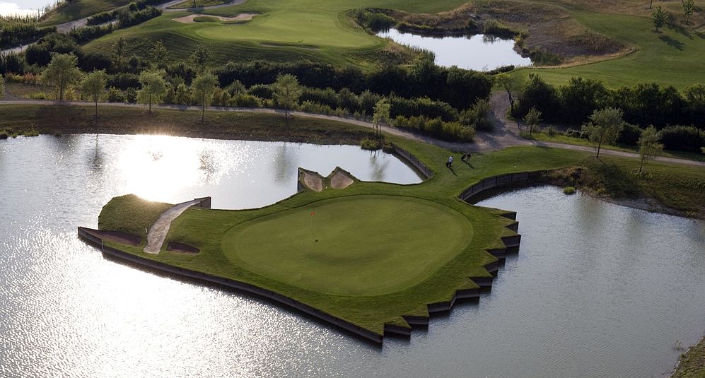 Blick von oben auf einen Teil eines Golfplatzes in Niedersachsen, der am Wasser liegt