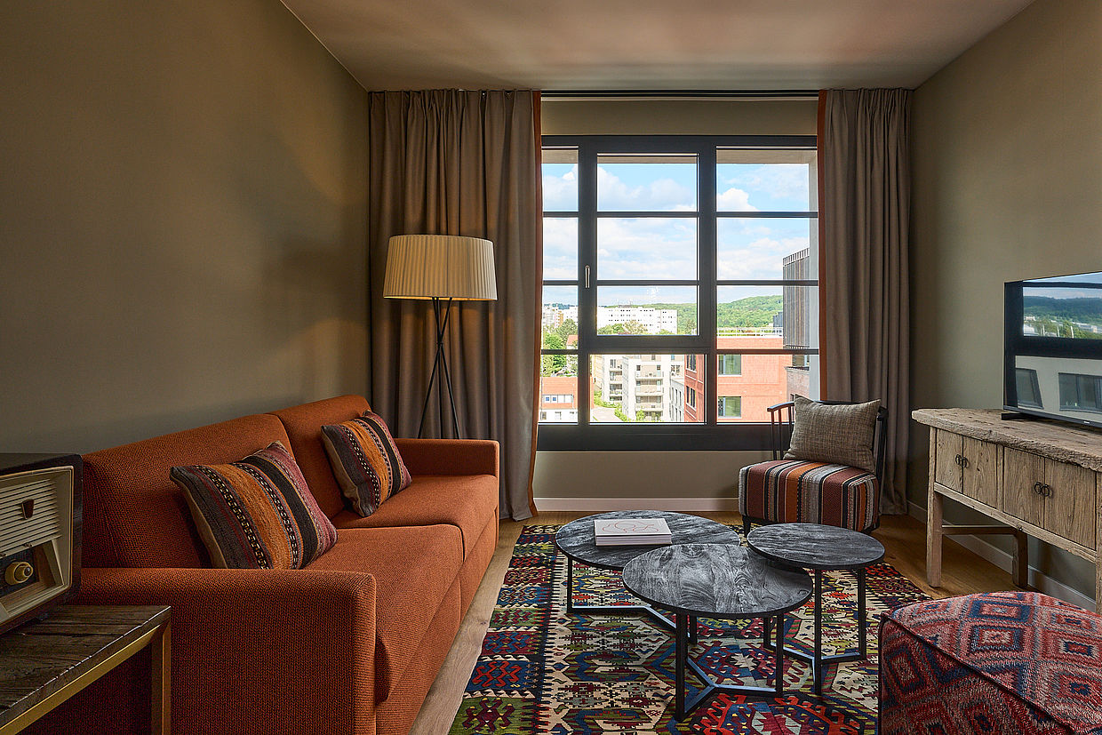 Ein gemütliches Hotelzimmer mit gemustertem Teppich und Kissen