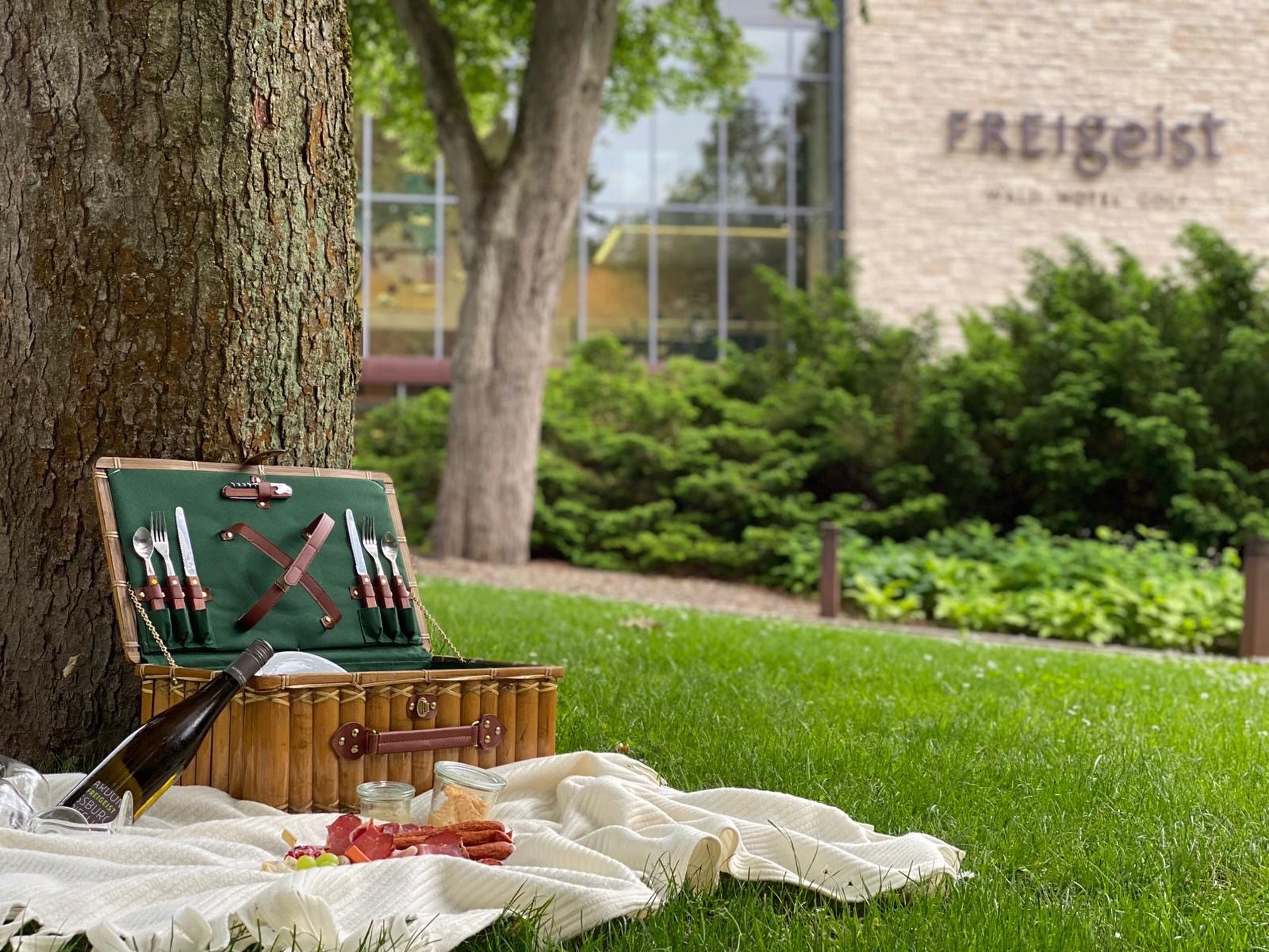 Ein Picknickkorb auf der grünen Wiese vor dem Hotel FREIgeist Northeim