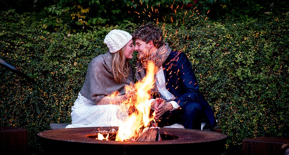 Ein Pärchen verbringt einen romantischen Abend am Lagerfeuer in ihrem Kurzurlaub in Niedersachsen