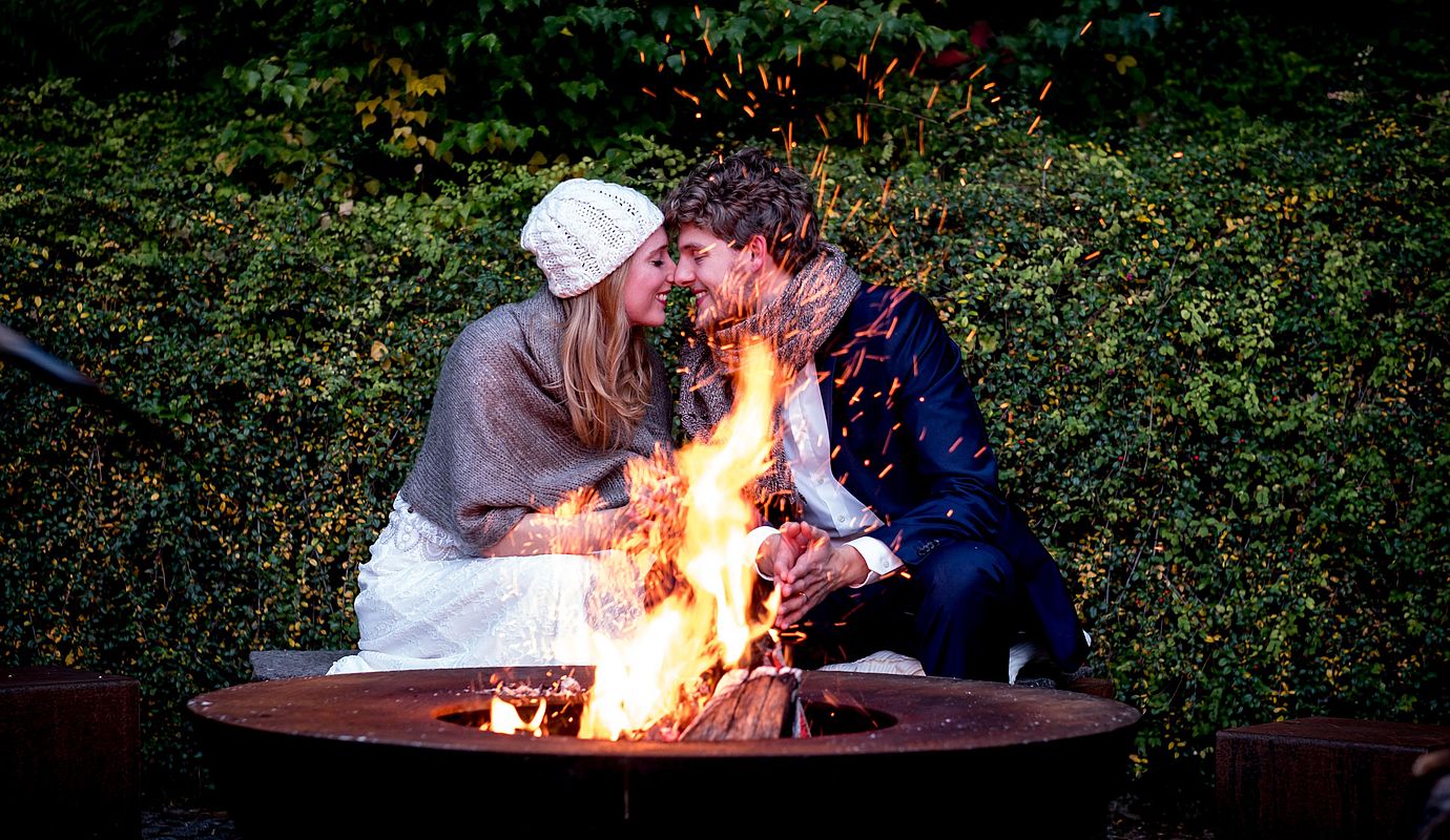 Ein Pärchen verbringt einen romantischen Abend am Lagerfeuer in ihrem Kurzurlaub in Niedersachsen